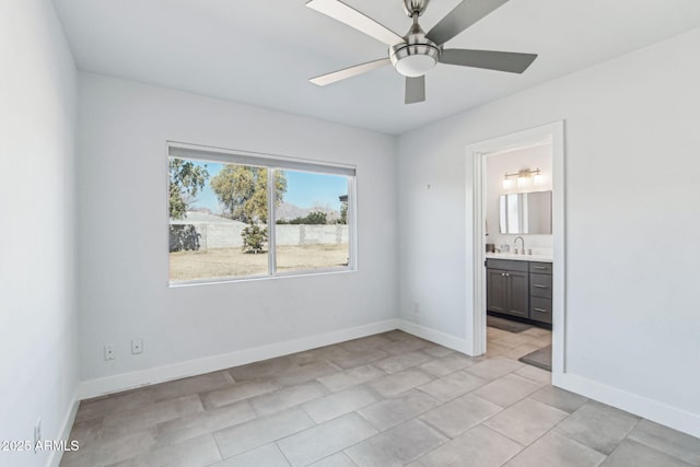 unfurnished bedroom with connected bathroom, sink, and ceiling fan