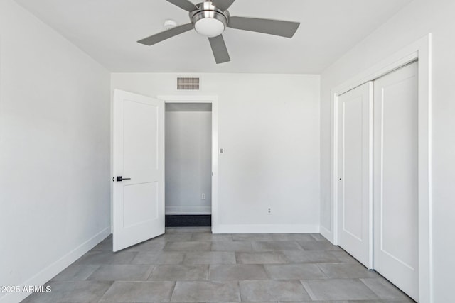 unfurnished bedroom with ceiling fan and a closet