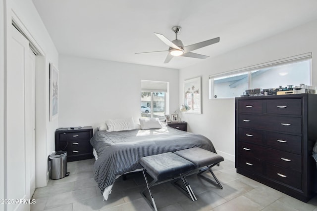 bedroom featuring light tile patterned floors, a closet, and ceiling fan