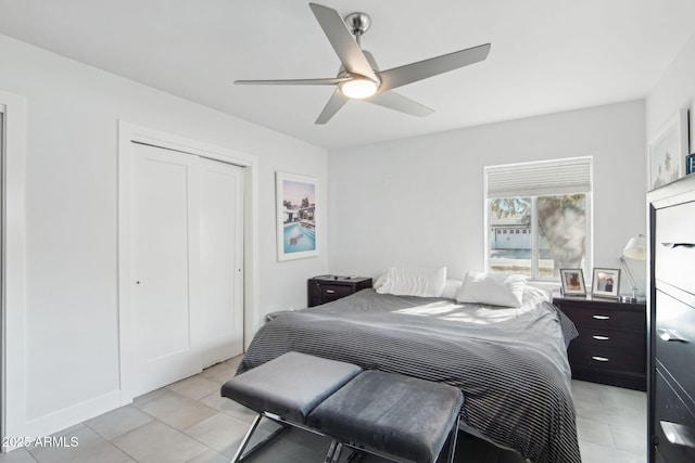 tiled bedroom with ceiling fan and a closet