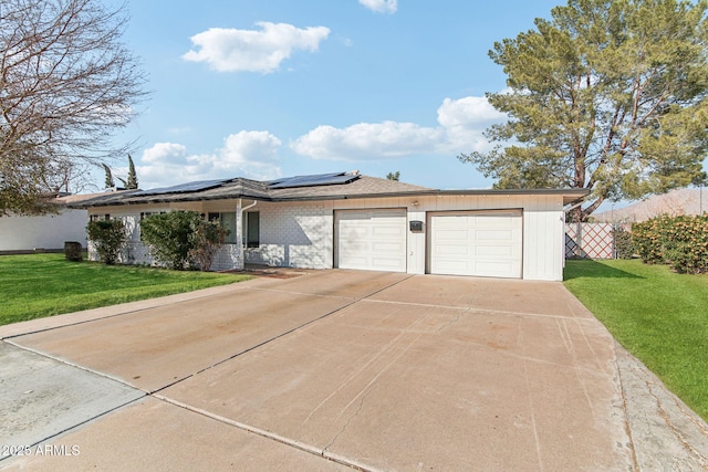 ranch-style house featuring a garage, a front lawn, and solar panels