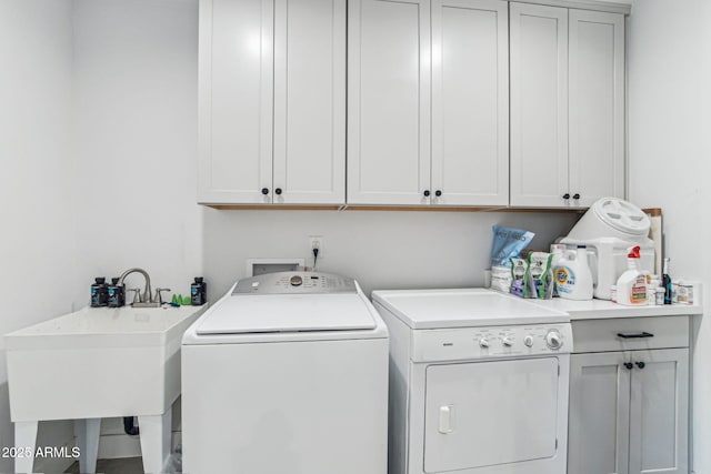 laundry area featuring separate washer and dryer, sink, and cabinets