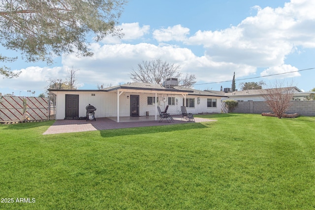 back of property with a yard and a patio area