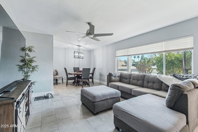 tiled living room featuring ceiling fan with notable chandelier