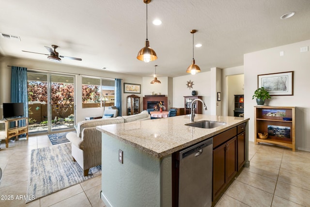 kitchen featuring a sink, dishwasher, light tile patterned floors, a ceiling fan, and light stone counters