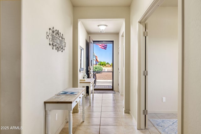 hallway featuring light tile patterned flooring and baseboards