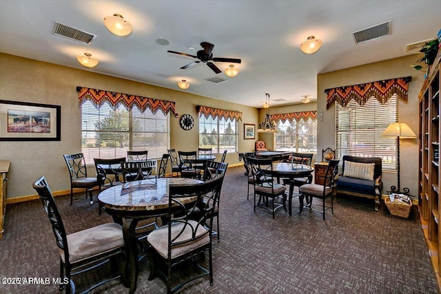 dining room with dark colored carpet, baseboards, and ceiling fan
