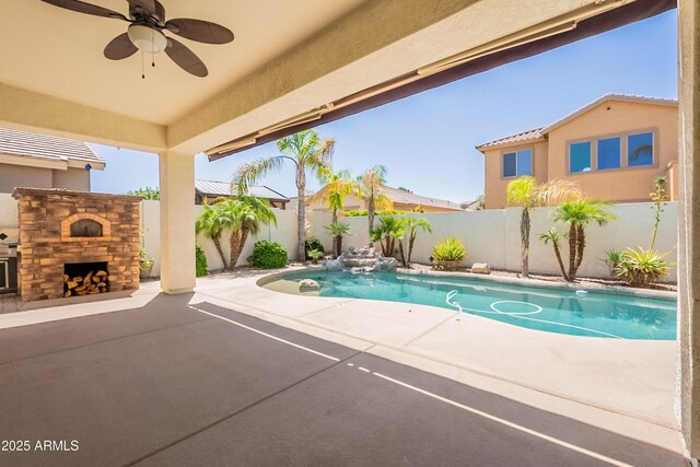 3971 E Leo Pl, Chandler, AZ 85249 - view of swimming pool with a patio area, a fenced backyard, a ceiling fan, and an outdoor stone fireplace