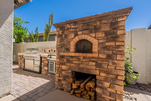 3971 E Leo Pl, Chandler, AZ 85249 - view of patio / terrace with an outdoor stone fireplace, exterior kitchen, fence, and area for grilling