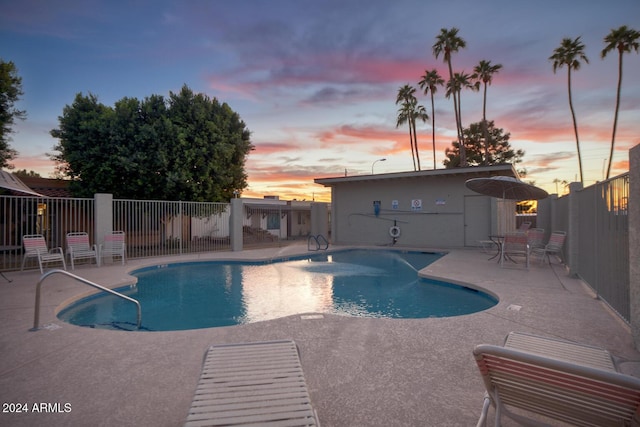 pool at dusk featuring a patio