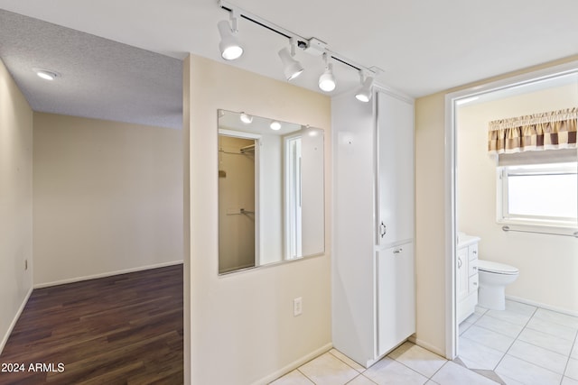 bathroom featuring hardwood / wood-style floors, vanity, toilet, and a textured ceiling