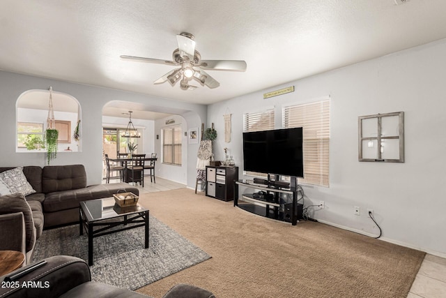 13359 W Post Dr, Surprise, AZ 85374 - living area with arched walkways, ceiling fan, light colored carpet, a chandelier, and light tile patterned floors