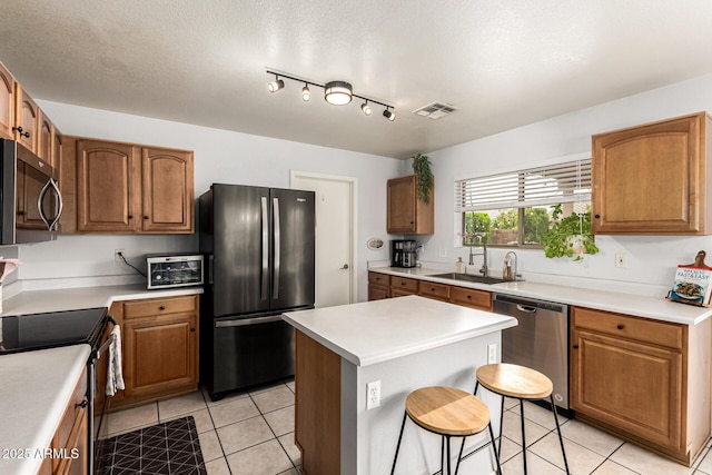 13359 W Post Dr, Surprise, AZ 85374 - kitchen with appliances with stainless steel finishes, a sink, light tile patterned flooring, and a breakfast bar area