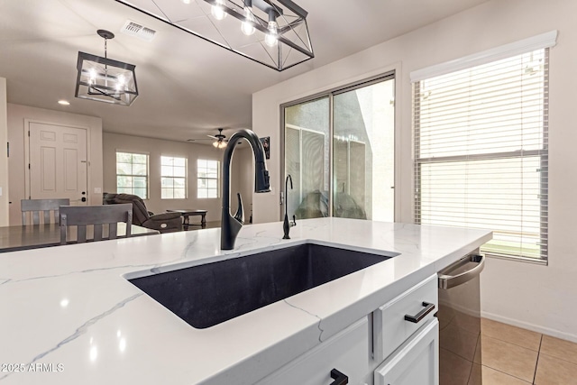 kitchen featuring visible vents, pendant lighting, a sink, white cabinetry, and light tile patterned floors