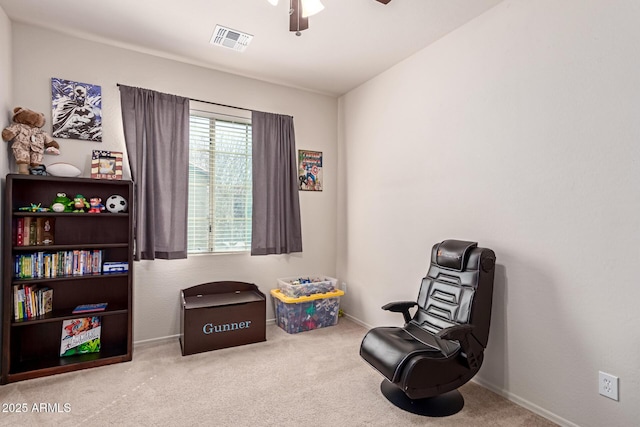 living area with visible vents, baseboards, carpet, and ceiling fan