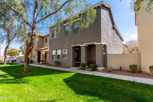 view of front facade featuring stucco siding, a front yard, and a tile roof