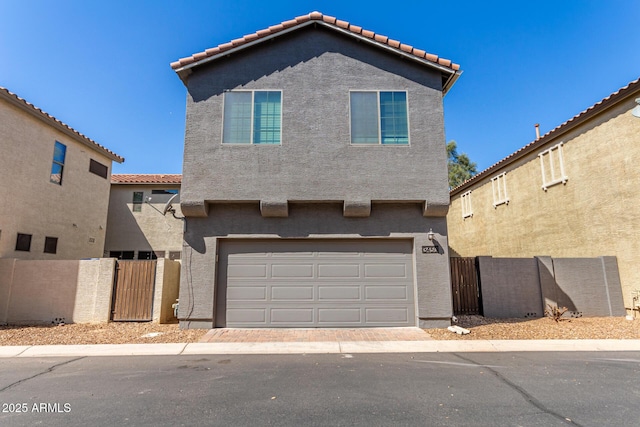 view of front of home with stucco siding, a tiled roof, and fence