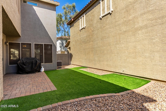 view of yard featuring fence, central AC unit, and a patio area