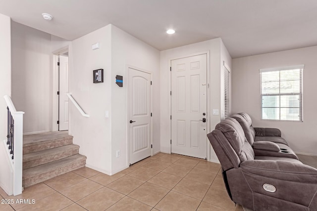 foyer with light tile patterned floors and stairs