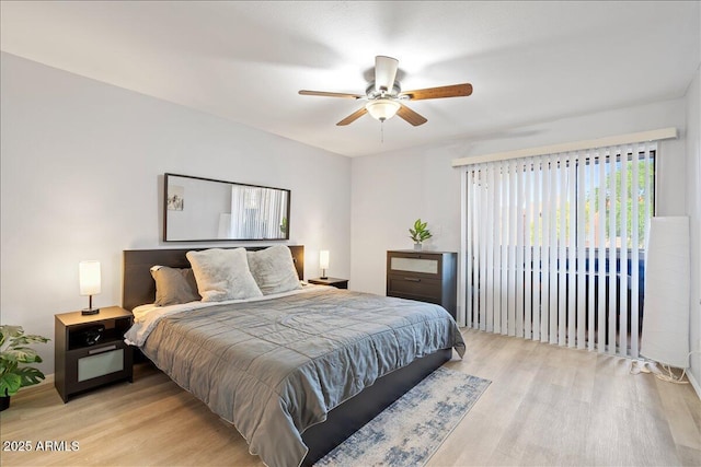 bedroom featuring light wood-type flooring, a ceiling fan, and access to exterior