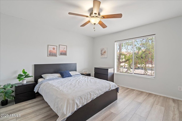 bedroom featuring light wood finished floors, baseboards, and a ceiling fan