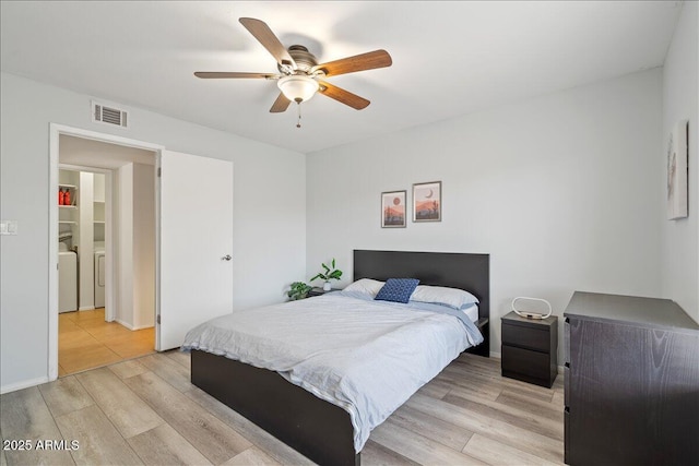 bedroom featuring washer and clothes dryer, light wood finished floors, ceiling fan, and visible vents