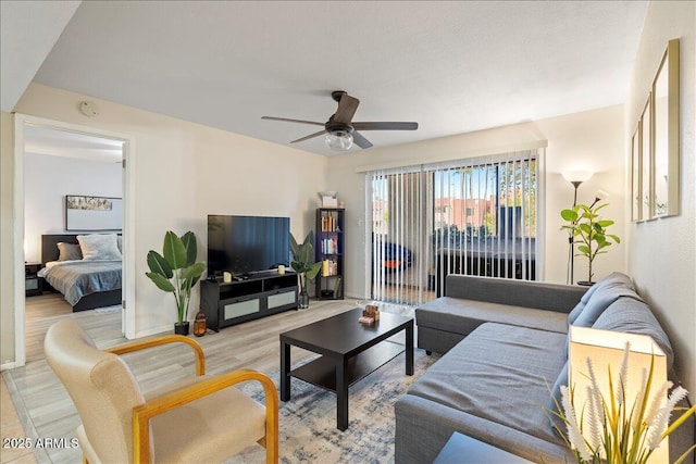 living room with baseboards, light wood-style flooring, and a ceiling fan