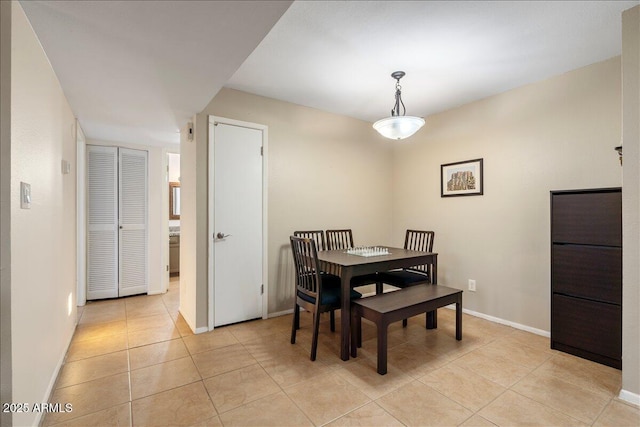 dining space featuring baseboards and light tile patterned floors
