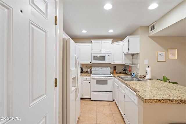 kitchen with light tile patterned floors, a sink, visible vents, white appliances, and light countertops