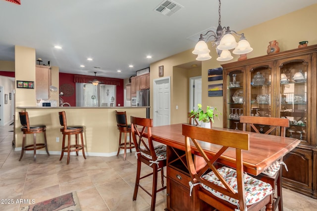 tiled dining area with a chandelier