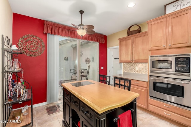 kitchen featuring light brown cabinetry, appliances with stainless steel finishes, tasteful backsplash, light tile patterned floors, and ceiling fan