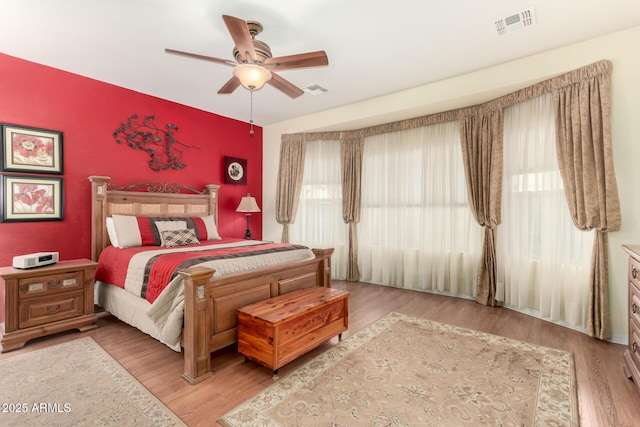 bedroom featuring wood-type flooring, multiple windows, and ceiling fan