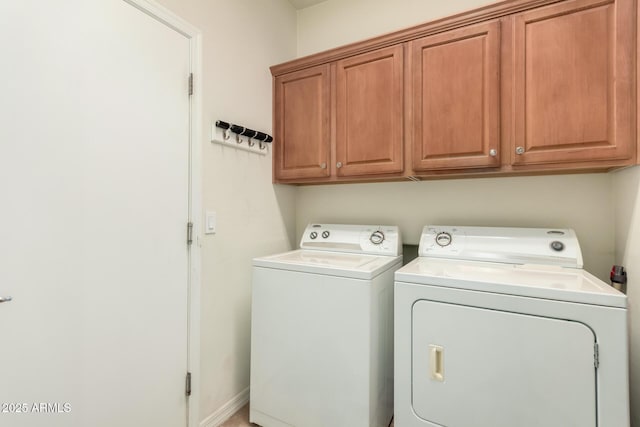 washroom featuring cabinets and washing machine and dryer