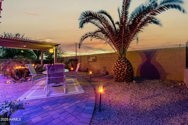 patio terrace at dusk featuring a pergola