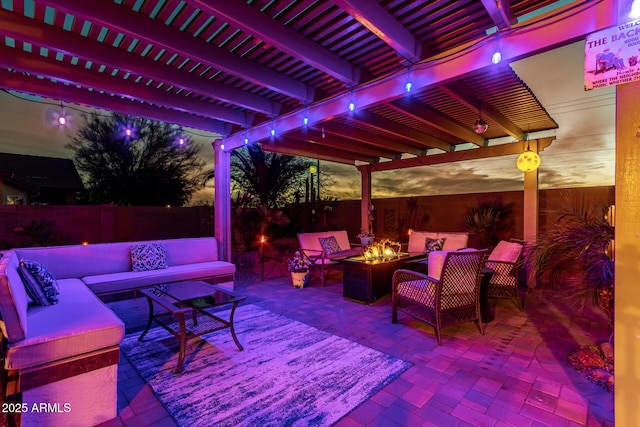 patio terrace at dusk featuring a pergola and an outdoor living space with a fire pit