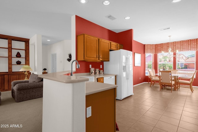 22622 N Mazatlan Dr, Sun City West, AZ 85375 - kitchen with a notable chandelier, a sink, light countertops, white fridge with ice dispenser, and visible vents
