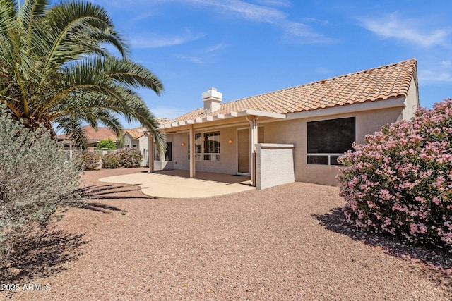 22622 N Mazatlan Dr, Sun City West, AZ 85375 - back of house with a patio area, stucco siding, a tiled roof, and a chimney