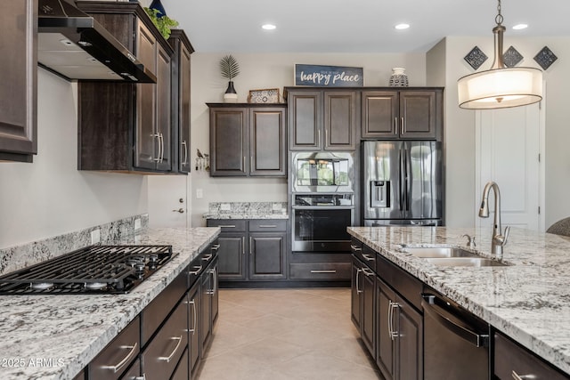 kitchen with dark brown cabinetry, sink, pendant lighting, stainless steel appliances, and wall chimney range hood