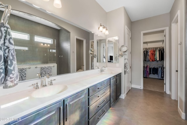 bathroom featuring vanity, tile patterned flooring, toilet, and tiled shower