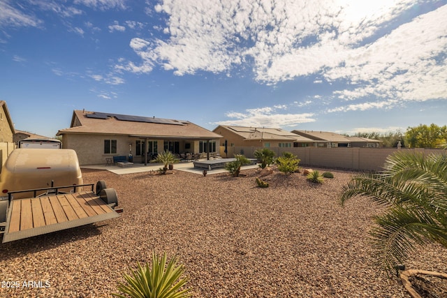 rear view of house featuring a patio and solar panels