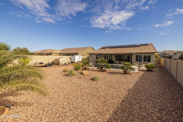 rear view of property with a patio and solar panels