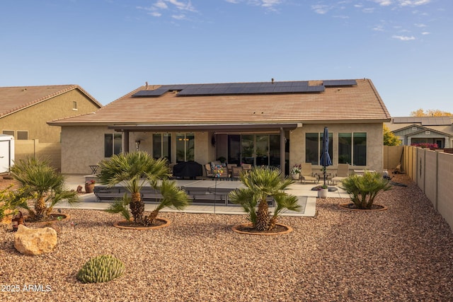 rear view of house with a patio and solar panels