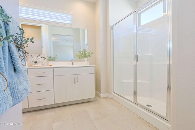 bathroom with tile patterned floors, a shower with door, and vanity