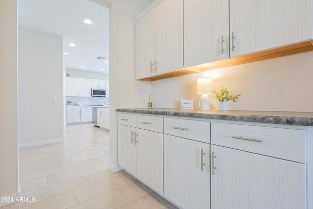 kitchen featuring light tile patterned flooring and white cabinetry