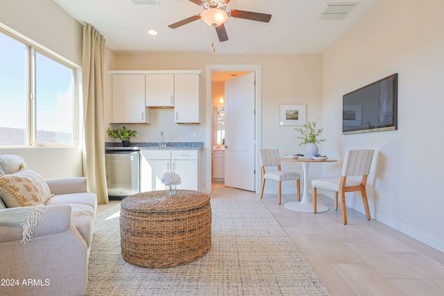 tiled living room featuring ceiling fan and sink