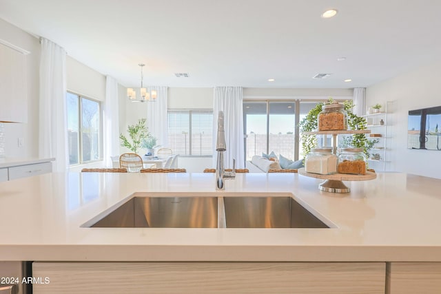 kitchen featuring sink, hanging light fixtures, and a notable chandelier