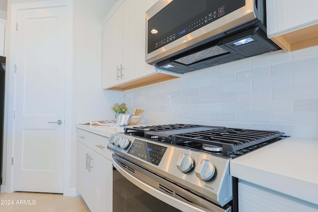 kitchen featuring light tile patterned flooring, white cabinetry, appliances with stainless steel finishes, and tasteful backsplash