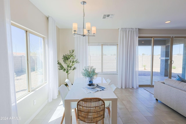 dining space with plenty of natural light, light tile patterned flooring, and a notable chandelier