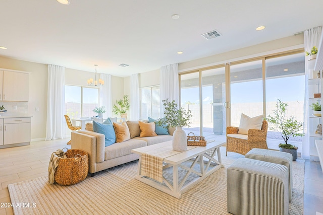 interior space with light hardwood / wood-style floors, plenty of natural light, and a notable chandelier