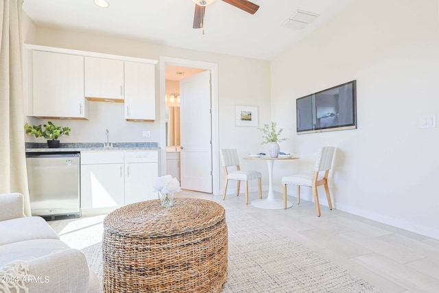 kitchen with white cabinetry, dishwasher, light tile patterned floors, and sink